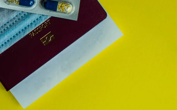 パスポートと医療スタッフとCovid 19ウイルスの概念コピースペース付き黄色のパステルの背景 — ストック写真