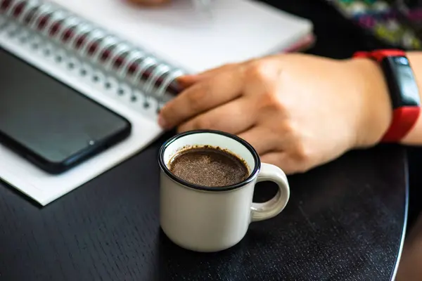 テーブルの上にコーヒー 携帯電話やノートパッドのカップで宿題のコンセプト — ストック写真