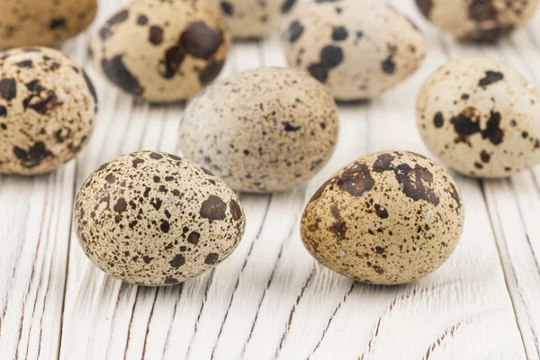 Quail eggs on old white wooden table. — Stock Photo, Image