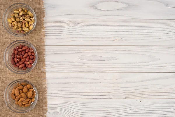 Mélanger les noix dans un bol en verre sur la vieille table en bois . — Photo