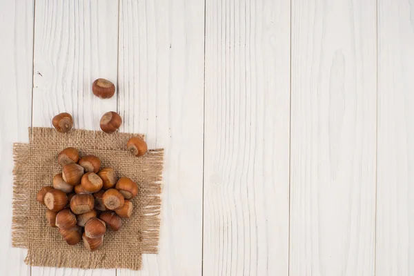 Nocciola sul sacco e un vecchio tavolo di legno . — Foto Stock