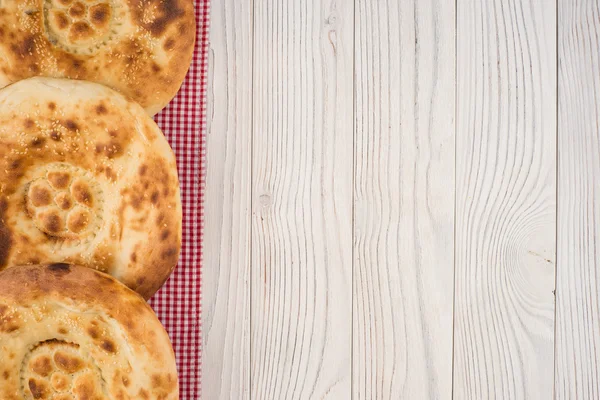 Pan uzbeko sobre una vieja mesa de madera blanca . —  Fotos de Stock
