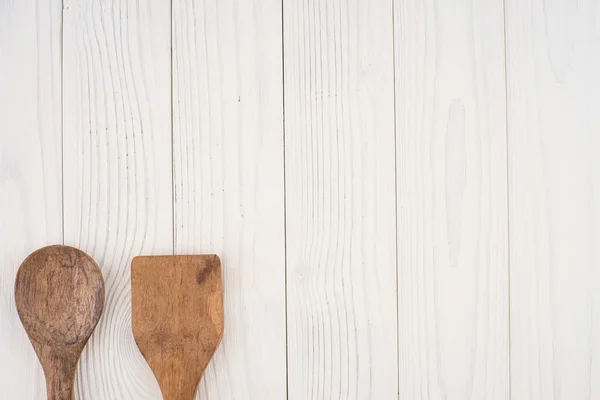 Cuchara de madera y espátula sobre una vieja mesa blanca . — Foto de Stock