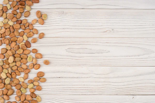 Os feijões na velha mesa de madeira . — Fotografia de Stock