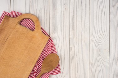 Kesme tahtası ve bir kaşık mutfak peçete üzerinde eski ahşap tabl