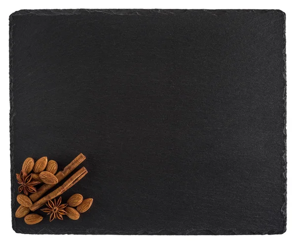 Almonds, cinnamon and star anise on a black slate board. Isolate — Stock Photo, Image