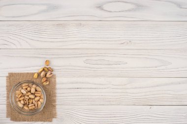 Eski Beyaz ahşap masa bir cam kase fıstık fındık.