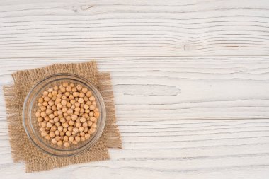 Eski ahşap masa üzerinde bir cam kapta nohut. 