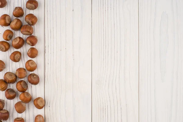 Haselnüsse auf einem alten Holztisch. abstrakter Hintergrund, leere Zeitspanne — Stockfoto