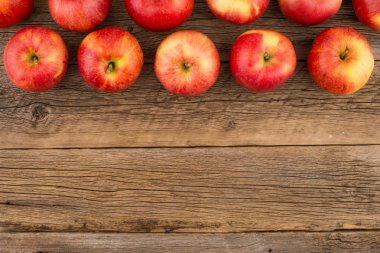 Eski ahşap masa üzerinde kırmızı elmalar. 