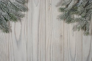 Çam dalları ile kar üzerinde eski bir beyaz ahşap masa. 