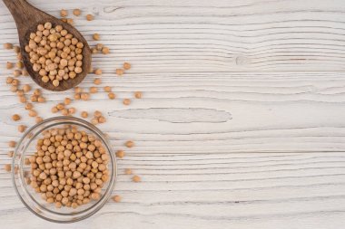 Tahta kaşık ve eski ahşap masa üzerinde cam kase nohut. 