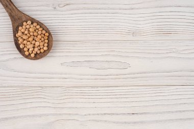 Eski ahşap masa üzerinde bir tahta kaşık nohut. 