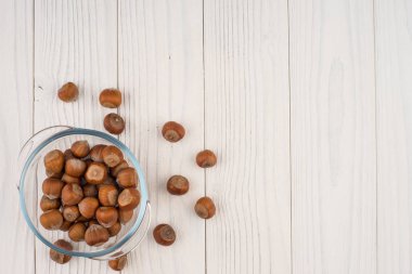 Eski Beyaz ahşap masa bir cam kase fındık. 