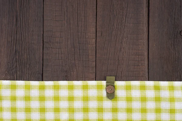 Mantel a cuadros verde sobre mesa de madera . — Foto de Stock