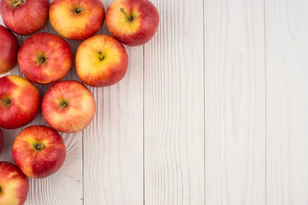 Eski ahşap masa üzerinde kırmızı elmalar. 