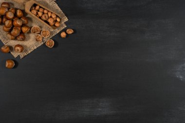 Siyah yazı tahtası ahşap bir vurgunun içinde fındık.
