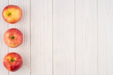 Eski ahşap masa üzerinde kırmızı elmalar. 