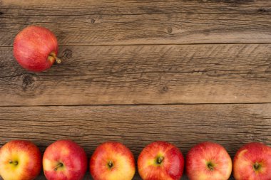 Eski ahşap masa üzerinde kırmızı elmalar. 