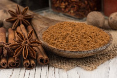 Eski beyaz tahta masada bir tahta kaşık tarçın zemin.