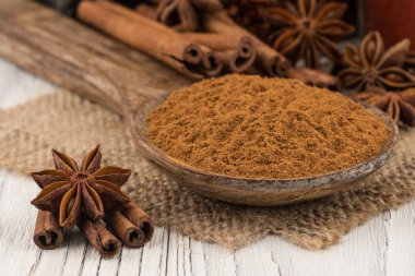 Eski beyaz tahta masada bir tahta kaşık tarçın zemin.