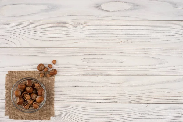 Nocciola in una ciotola di vetro su un vecchio tavolo di legno bianco . — Foto Stock