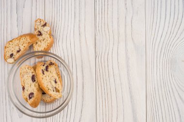 Eski ahşap masa üzerinde bir cam kasede bisküvi.