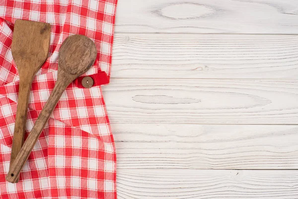 Cuchara de madera y espátula en una servilleta y una vieja lengüeta de madera blanca — Foto de Stock