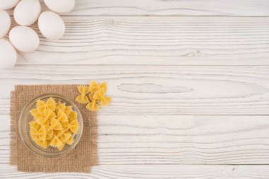 Eski ahşap masa üzerinde bir cam kapta makarna. 