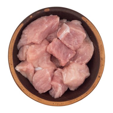 Çiğ et kahverengi bir tabak içinde parçalar halinde kesilir. Beyaz izole 