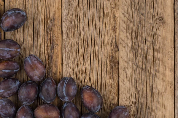 Ameixas frescas em uma mesa de madeira escura . — Fotografia de Stock