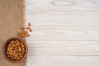 Badem bir kahverengi kase ve eski Beyaz ahşap masa. 