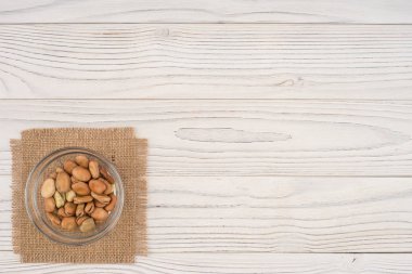 Eski ahşap masa üzerinde bir cam kabın içinde fasulye. 