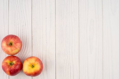 Eski ahşap masa üzerinde kırmızı elmalar. 