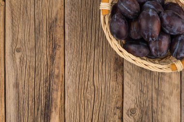 Eski ahşap masa sepetteki Erik. 