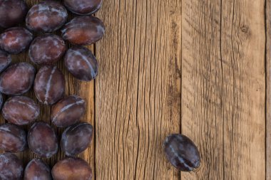 Koyu ahşap bir masa üzerinde taze Erik.