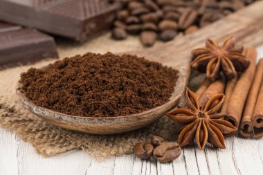 Eski beyaz tahta masada bir tahta kaşık çekilmiş kahve. 