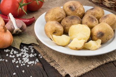 plaka üzerinde eski bir ahşap masa içinde fırında patates. 