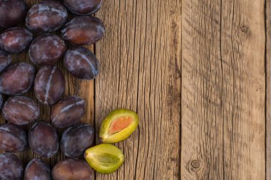 Koyu ahşap bir masa üzerinde taze Erik. 