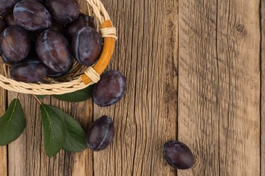 Koyu ahşap bir masa üzerinde taze Erik. 