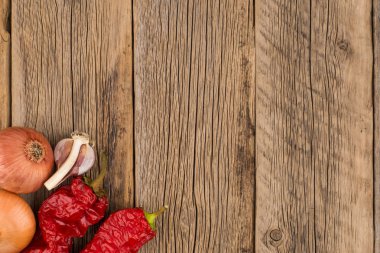 Soğan, sarımsak ve biber eski ahşap tablo. 