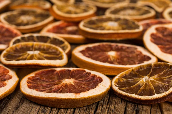 Dried oranges and grapefruits on an old wooden table. — Stock Photo, Image