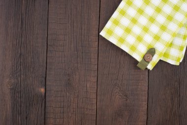 Ahşap masa üzerinde yeşil kareli masa örtüsü. 