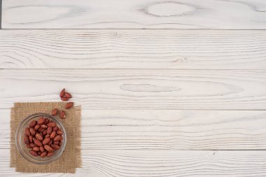 Eski ahşap masa üzerinde bir cam kase fıstık. 