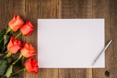 Boş defter, kalem ahşap bir masa üzerinde bir Güllü. 