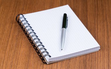 Kalem ve defter bir ahşap ofis masasında. 