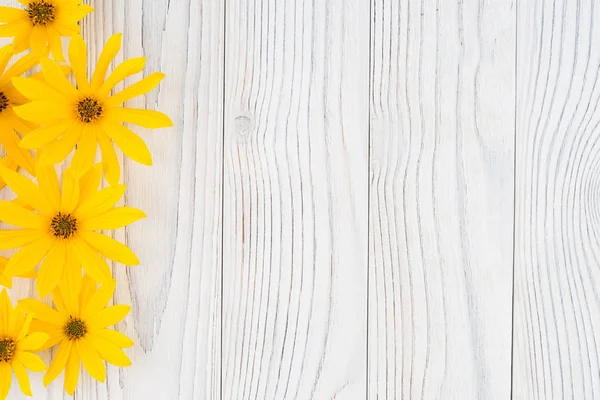 Fiore selvatico giallo su vecchio tavolo di legno bianco . — Foto Stock