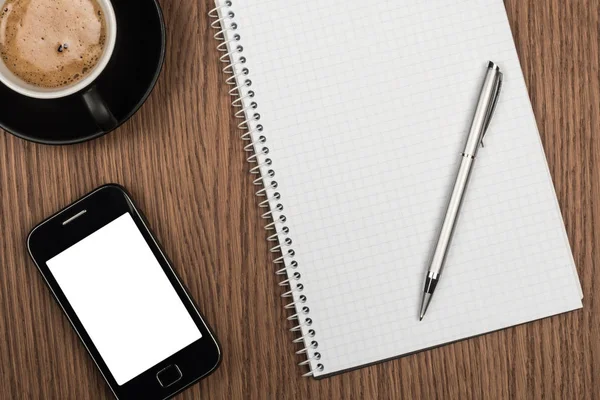 Coffee cup and blank notepad over wooden table. — Stock Photo, Image