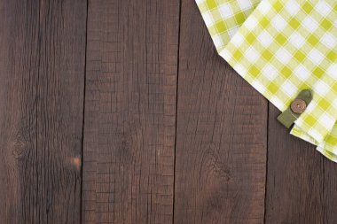 Ahşap masa üzerinde yeşil kareli masa örtüsü. 