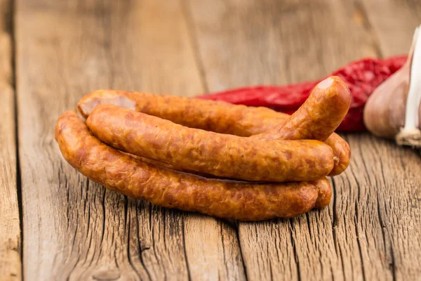 Sausages on an old wooden table. — Stock Photo, Image